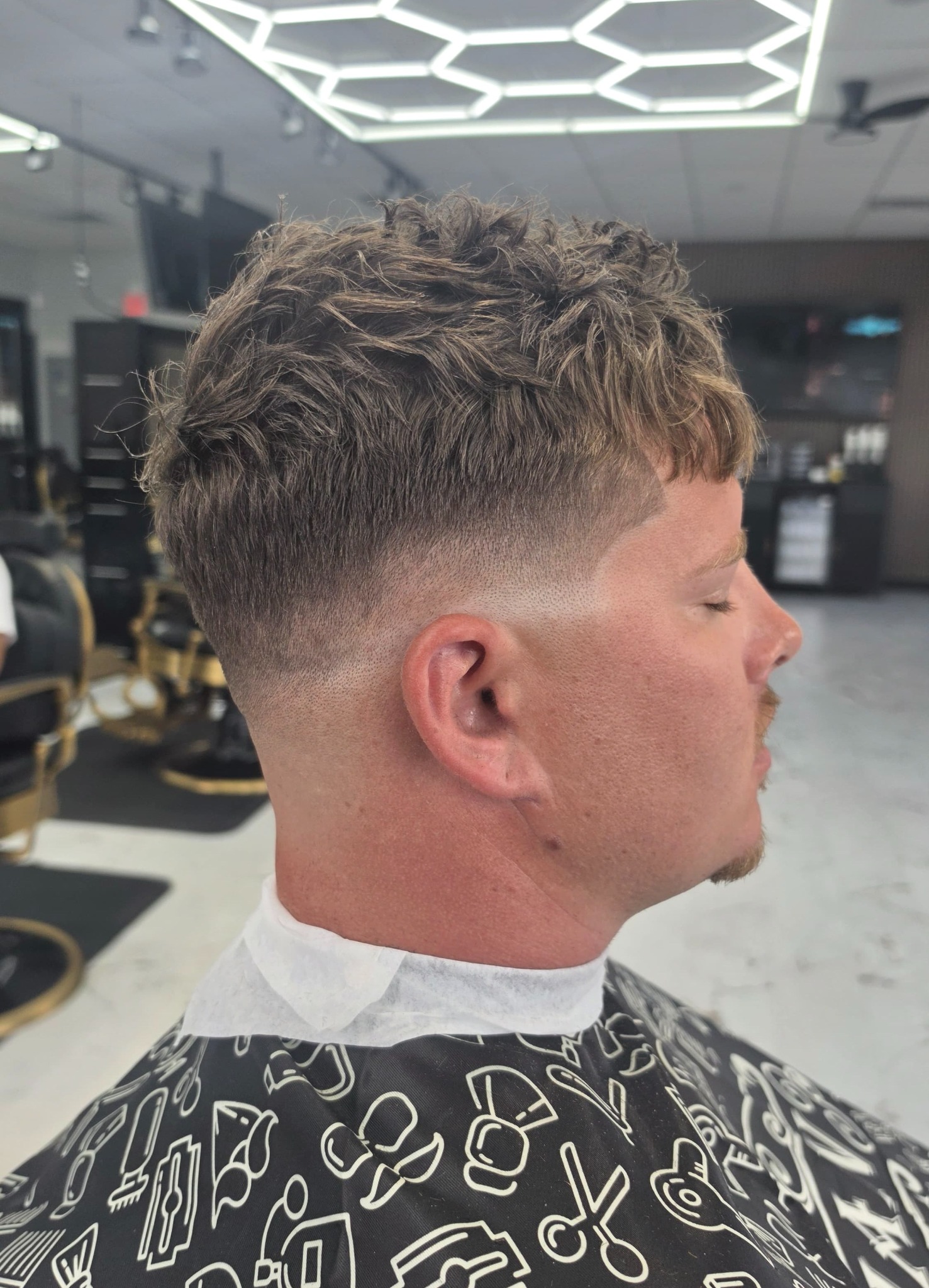 Adult haircut with a clean fade and textured top